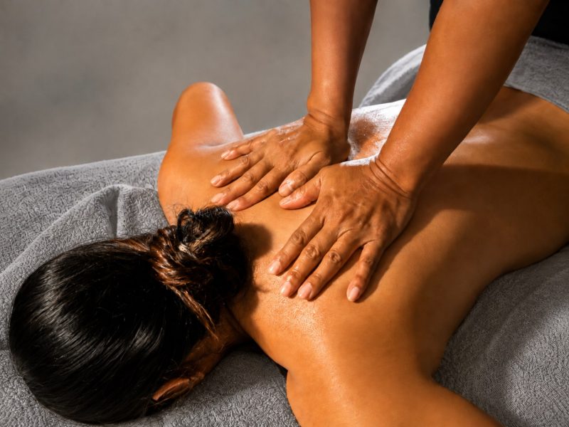 Therapist performing a Swedish massage on a guest's back